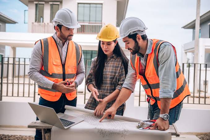 Equipe no canteiro revisando projetos, usando Inteligência Artificial na Construção Civil para aumentar a segurança do trabalho.